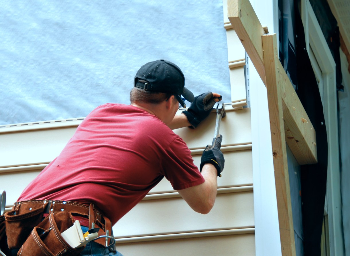 installs siding holding a hammer and wearing a tool belt stephentown ny